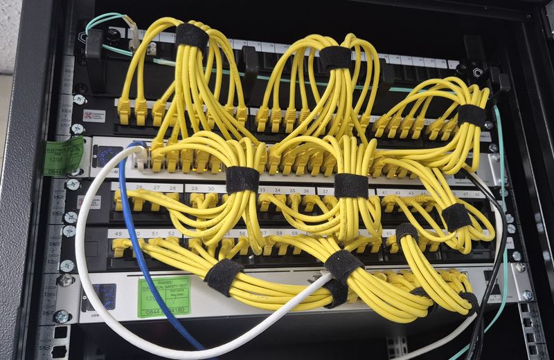 A neatly dressed network rack with yellow patch leads bundled and labelled